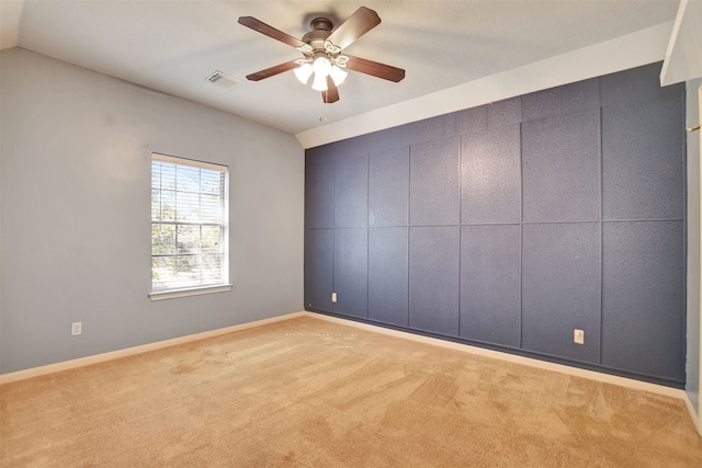 empty room with light carpet, ceiling fan, and vaulted ceiling