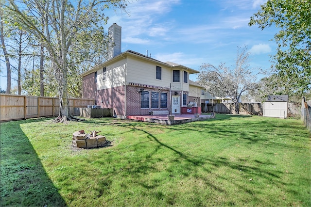 back of property featuring a storage shed, a yard, an outdoor fire pit, and a patio area