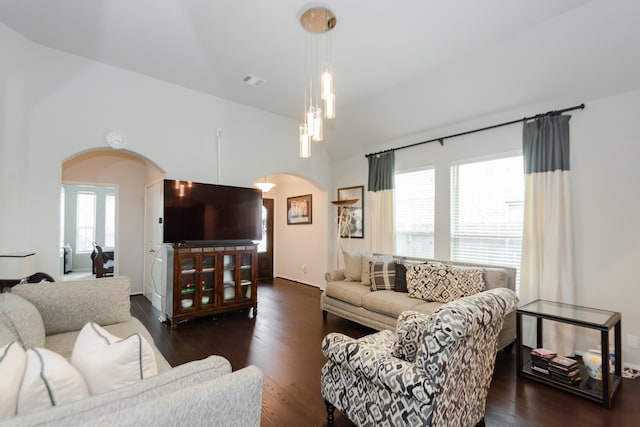 living room featuring plenty of natural light, dark hardwood / wood-style floors, and vaulted ceiling