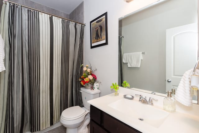 bathroom featuring tile patterned flooring, vanity, and toilet