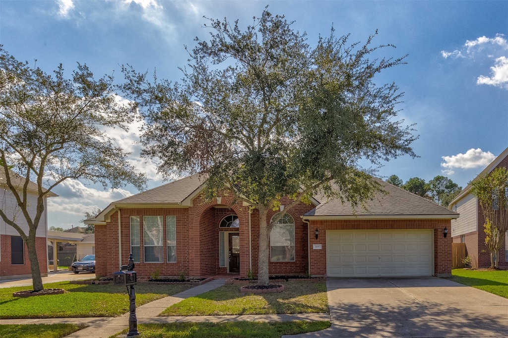 view of front of property featuring a front yard and a garage