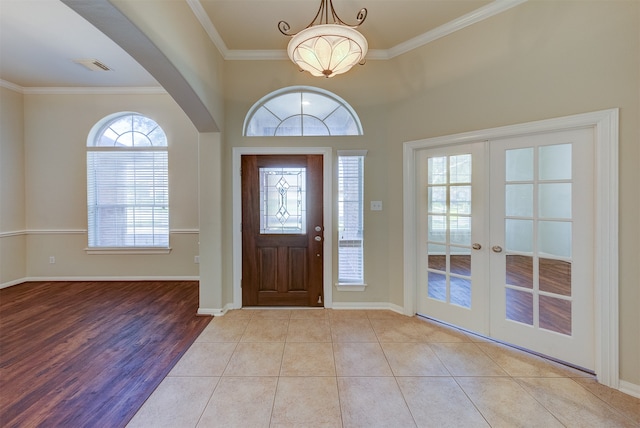 entryway featuring french doors, crown molding, and light hardwood / wood-style flooring