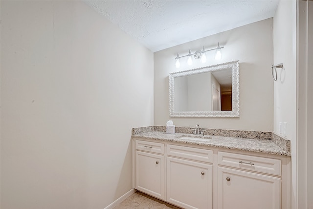 bathroom featuring a textured ceiling and vanity