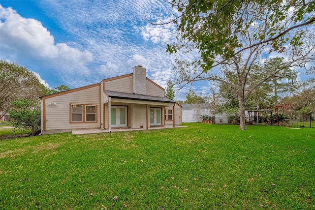 back of property with a lawn and a patio