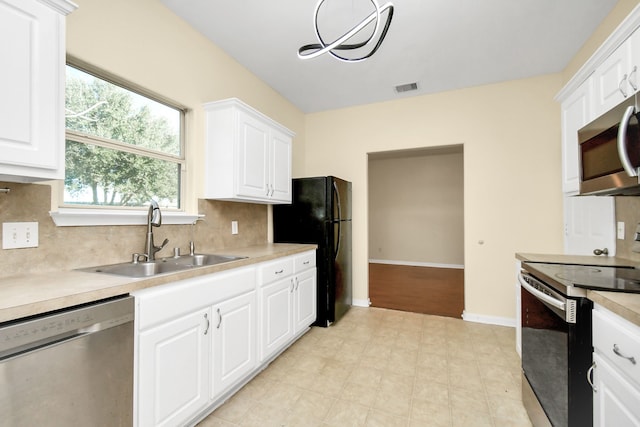 kitchen featuring white cabinets, appliances with stainless steel finishes, backsplash, and sink