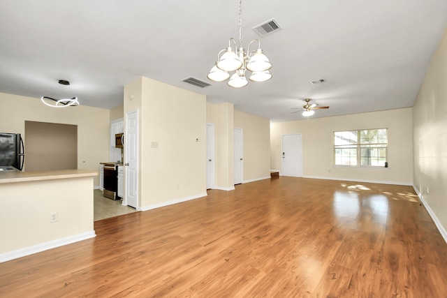 unfurnished living room with ceiling fan with notable chandelier and light wood-type flooring