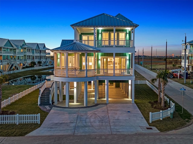 back house at dusk with a balcony and a carport