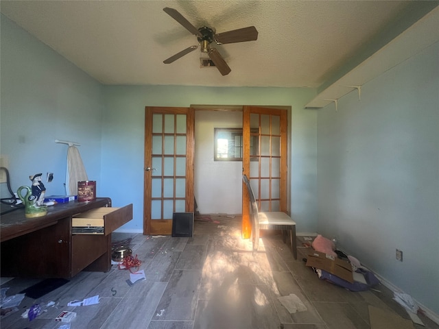 misc room featuring french doors, a textured ceiling, dark hardwood / wood-style floors, and ceiling fan