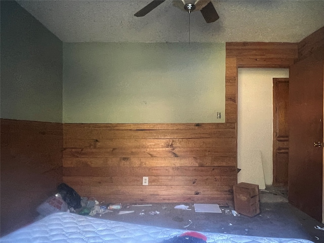 unfurnished room featuring ceiling fan and wooden walls