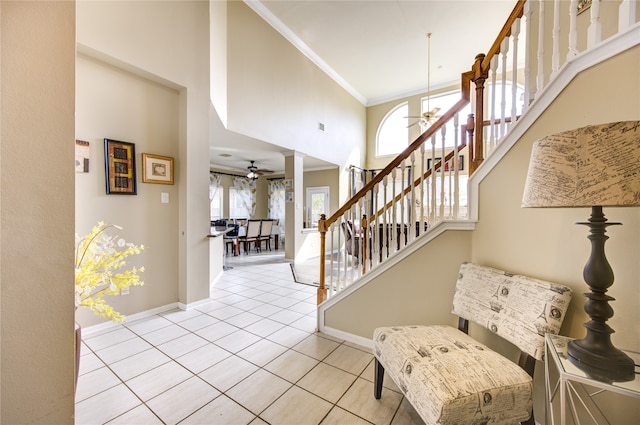 foyer featuring ornamental molding, light tile patterned floors, ceiling fan, and a healthy amount of sunlight