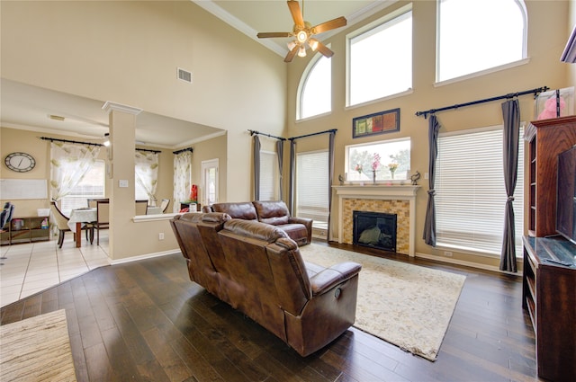 living room featuring a towering ceiling, dark hardwood / wood-style floors, and plenty of natural light