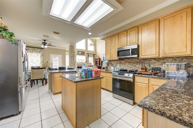 kitchen featuring ceiling fan, a center island, crown molding, and appliances with stainless steel finishes