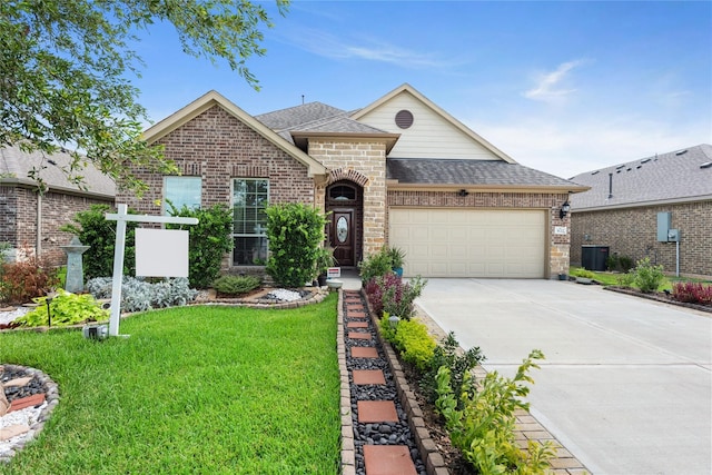 view of front of house featuring a front lawn, a garage, and central AC