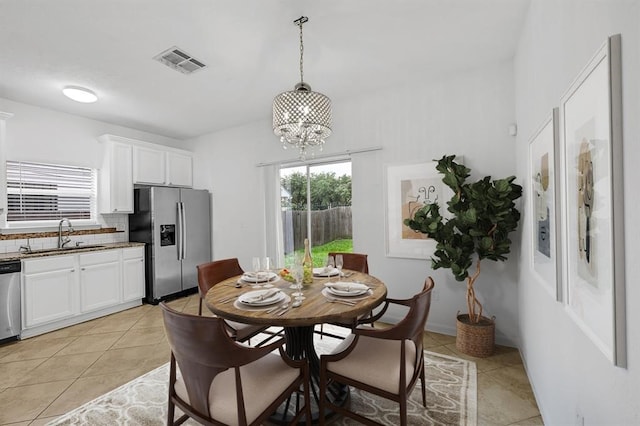 dining room with a notable chandelier, light tile patterned flooring, and sink