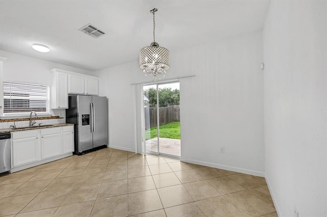 kitchen featuring sink, white cabinets, stainless steel appliances, and an inviting chandelier