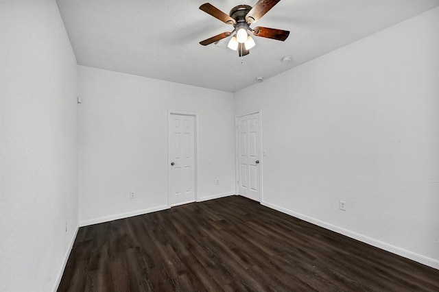 unfurnished room with ceiling fan and dark wood-type flooring