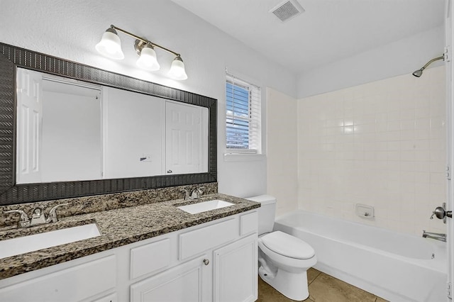 full bathroom with tile patterned floors, vanity, tiled shower / bath combo, and toilet