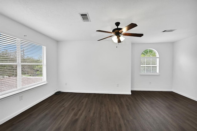 unfurnished room featuring ceiling fan, dark wood-type flooring, and a textured ceiling