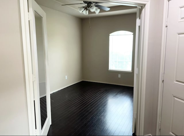 empty room with ceiling fan and dark wood-type flooring