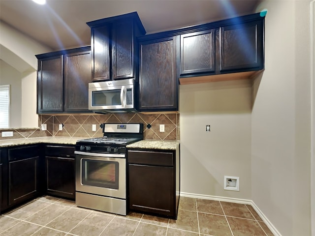 kitchen with backsplash, light stone counters, light tile patterned floors, and stainless steel appliances