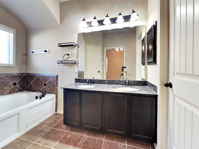 bathroom featuring tile patterned flooring, vanity, and a washtub