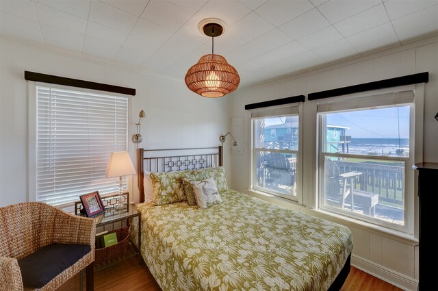 bedroom with wood-type flooring and crown molding