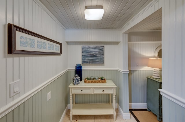 corridor featuring wood walls and crown molding