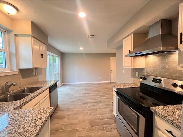 kitchen with white cabinets, appliances with stainless steel finishes, wall chimney exhaust hood, and sink