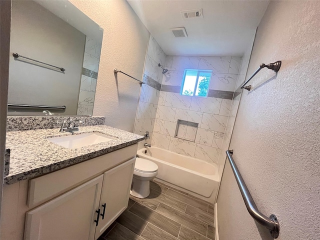 full bathroom with vanity, toilet, and tiled shower / bath combo