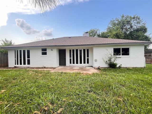 back of property with a patio area and a lawn