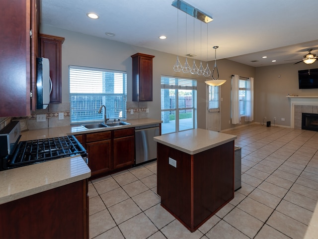 kitchen featuring tasteful backsplash, stainless steel appliances, sink, pendant lighting, and a kitchen island