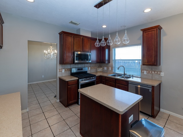 kitchen featuring pendant lighting, sink, appliances with stainless steel finishes, tasteful backsplash, and a kitchen island