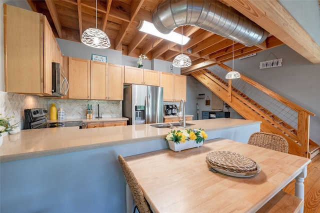 kitchen with pendant lighting, light brown cabinets, sink, appliances with stainless steel finishes, and kitchen peninsula