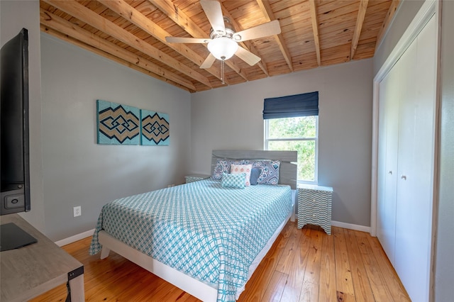 bedroom featuring ceiling fan, beam ceiling, wooden ceiling, light hardwood / wood-style floors, and a closet