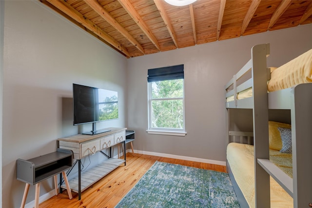 bedroom with beamed ceiling, wood-type flooring, and wood ceiling