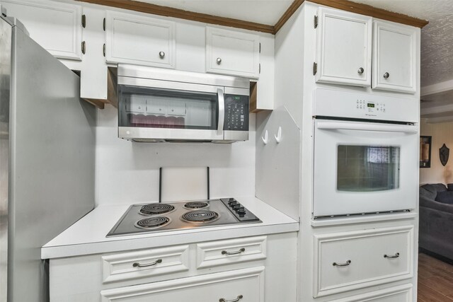 kitchen with stainless steel appliances, white cabinetry, and hardwood / wood-style flooring