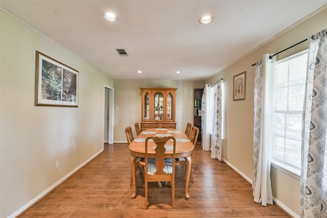 dining area featuring crown molding and light hardwood / wood-style floors