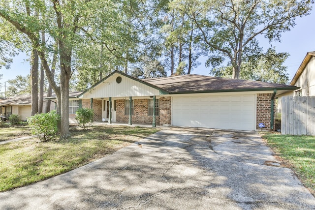 ranch-style house featuring a porch, a garage, and a front yard