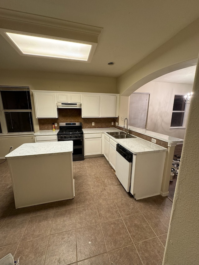 kitchen featuring gas stove, dishwasher, sink, light tile patterned floors, and white cabinets