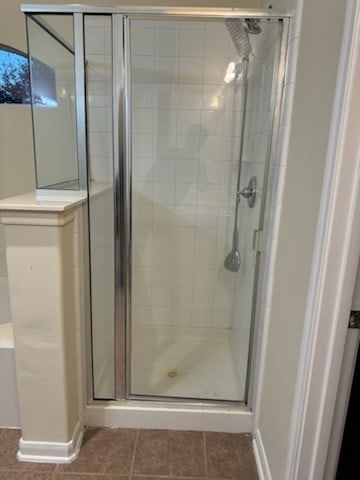 bathroom featuring tile patterned floors and a shower with shower door