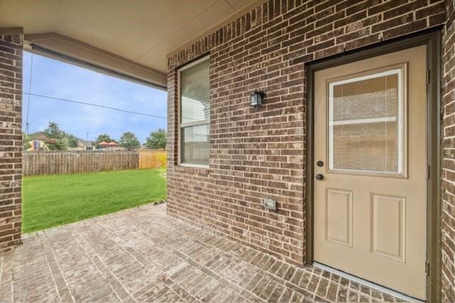 doorway to property featuring a lawn and a patio