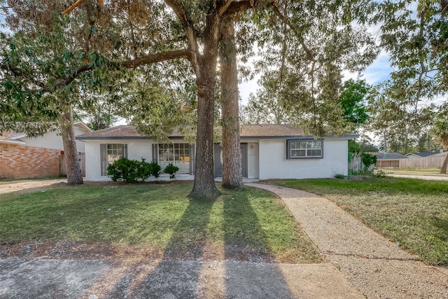 ranch-style home with a front lawn