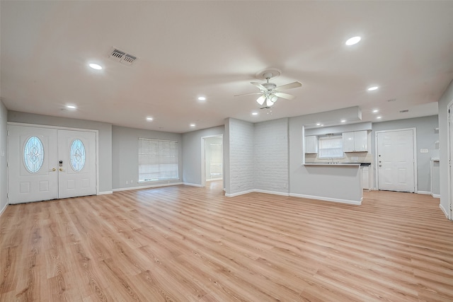 unfurnished living room with light wood-type flooring and ceiling fan