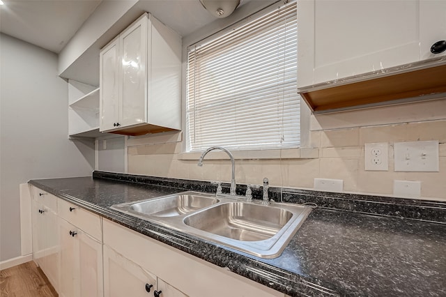 kitchen featuring white cabinets, backsplash, sink, and hardwood / wood-style flooring