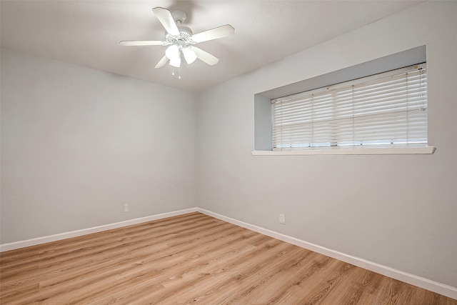 empty room with ceiling fan, a healthy amount of sunlight, and light wood-type flooring