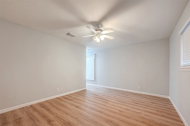 spare room with ceiling fan, light hardwood / wood-style flooring, and a textured ceiling