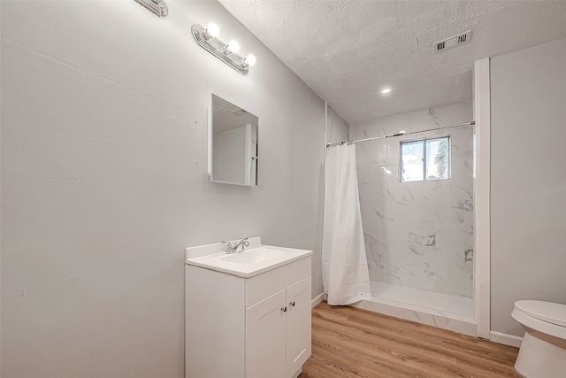 bathroom featuring a shower with curtain, vanity, hardwood / wood-style flooring, and a textured ceiling