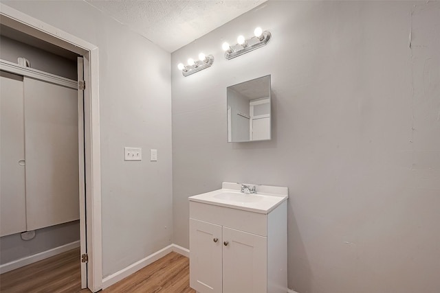 bathroom with vanity, wood-type flooring, and a textured ceiling