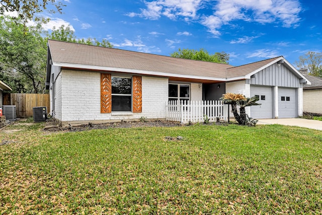 ranch-style home with central AC unit, a garage, and a front lawn