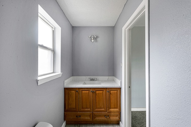 bathroom featuring a textured ceiling and vanity